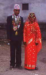 Raj Kumar Nepalis Hochzeit. (Er im dunklen Anzug mit traditioneller Mütze und Schmuck; Sie im rot-goldenen Sari mit Schleier.)
